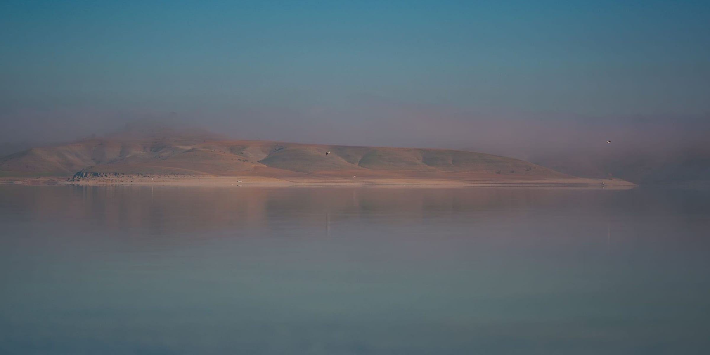Still water at first light beneath quiet architectural lines — a calm, considered scene